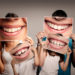 oral hygiene - a family holding photos of their smiles at beach grove dental tsawwassen